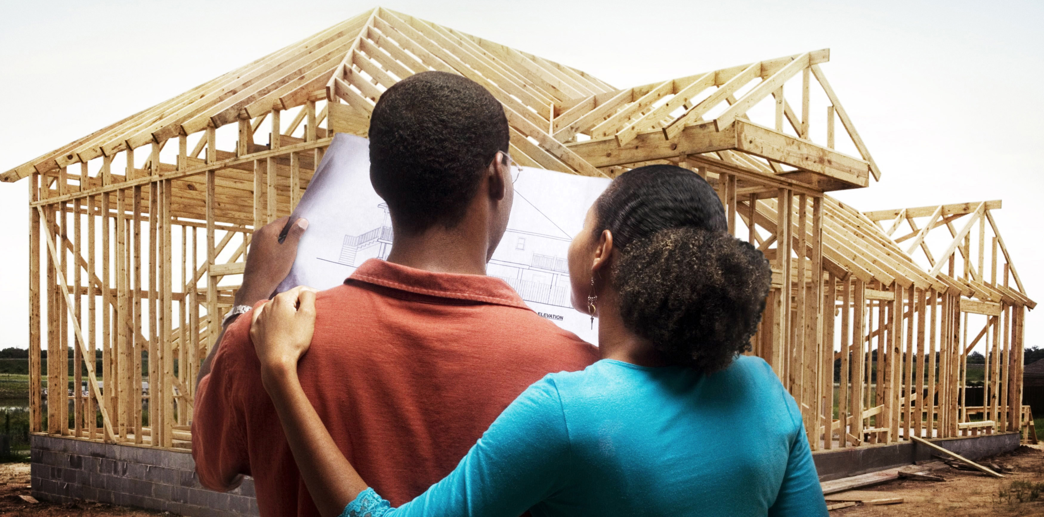 Couple looking at blueprint of home under construction